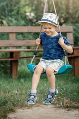 Very happy child to swing in the grandmother summer garden during the holidays.