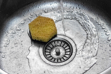 Water is pouring into the kitchen sink. Washing dishes. home plumbing