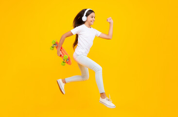 Fototapeta na wymiar Happy teenager portrait. Studio shot of trendy teenage fashion model in casual look. Teenager youth hipster urban lifestyle. Jump and run. Child girl in street style in hipster clothes with a