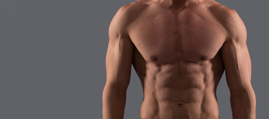 Man sexy bare torso, banner with copy space. He is in good shape. Shirtless guy in sports shorts. Fit guy grey background. Sporting man.