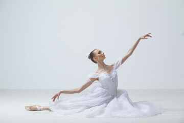 Fototapeta na wymiar Young Beautiful Female Ballerina Posing on Studio Background