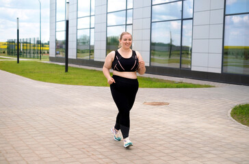 Obraz premium A fat obese woman in a tracksuit does a morning jog on the sidewalks of city streets. Plump person loses weight by running every day