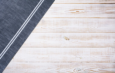 Smooth blue tablecloth, napkin, rough fabric texture on wooden desk top view.