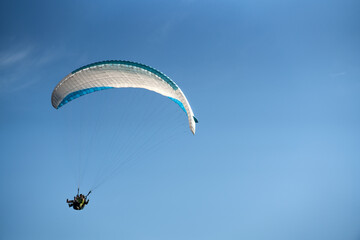 Paraglider in the blue sky. The sportsman flying on a paraglider.