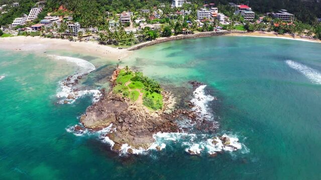 Parrot Rock Hill washed by Indian ocean waves flying drone beautiful Nature's landmark 4K video in Mirissa, Matara District on Sri Lanka. Exotic Asian countries and around the World traveling concept