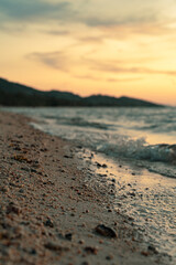 Sandy beach, surf and coastline at colorful sunset