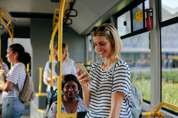 Young caucasian woman texting on city bus