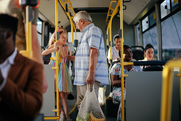 Girl and her grandfather traveling by public bus