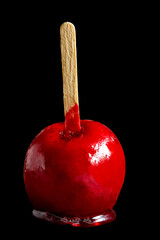 brazilian red love apple, traditional dessert, known as 'maça do amor' isolated on black background