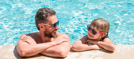 Father and son in swimming pool, banner with copy space. dad and child having fun at pool party. childhood and parenting. father and son