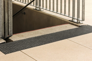 Drainage Mesh in front of Stairs . Drain on Ground Floor. Drainage Grid front of Exit to Stairway Outside. Staircase with Drainage.