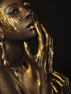 closeup beauty art portrait fantastic golden professional makeup african woman, lips skin hands with paint drops liquid gold. Fashion model sexy face goddess. Glitter shadow eyes glow glitter shine.