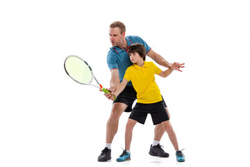 Male tennis player, coach training with teen to play tennis isolated over white studio background. Concept of sport, achievements, hobby, skills