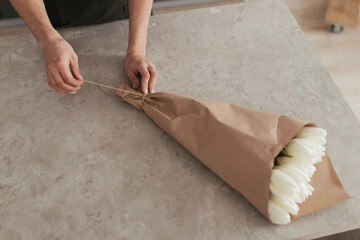 A man making a bouquet of flowers at home