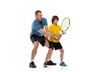 Training. Professional tennis player, coach teaches teen to play tennis isolated over white studio...