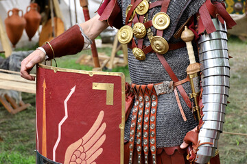 Legionary of Ancient Rome, close up of armor and scutum of infantry of Roman army on historical reconstruction festival
