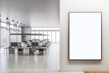Blank white poster on light wall in spacious sunlit coworking office with minimalistic workspaces, high ceiling, panoramic windows with city view and concrete floor. 3D rendering, mockup