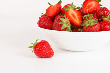 Red ripe strawberry in the white bowl, isolated