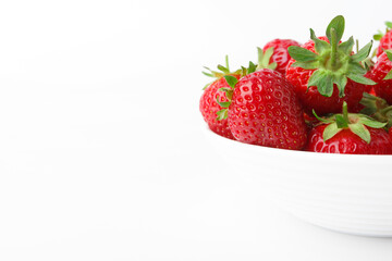 Red ripe strawberry in the white bowl, isolated