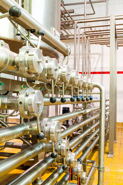 industrial interiors of a beverage factory. factory workshops with tanks, pipes, barrels, pumps, sensors, valves, conveyor