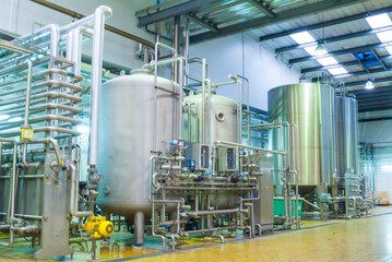 industrial interiors of a beverage factory. factory workshops with tanks, pipes, barrels, pumps, sensors, valves, conveyor