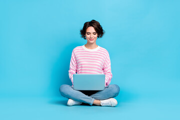 Photo of pretty positive lady browsing online shopping enjoying free time relaxing isolated on blue...