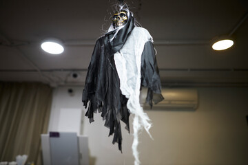 a skeleton in clothes hangs on the ceiling, Halloween decoration