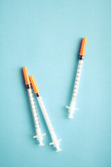 Medical syringes on blue background. Simple medicine concept flat lay.