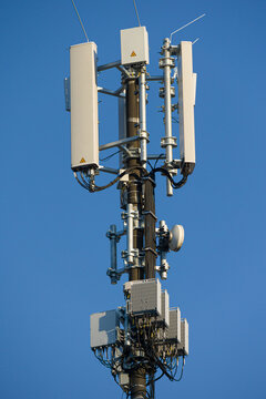 close-up of an antenna mast for mobile radio communications mounted at a roof top in front of blue sky 