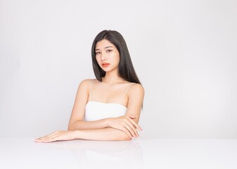 Obraz na płótnie Canvas Portrait of a young, smart and very beautiful clean asian sexy female lady wearing white tank top with different elegant poses and emotions against a white studio background