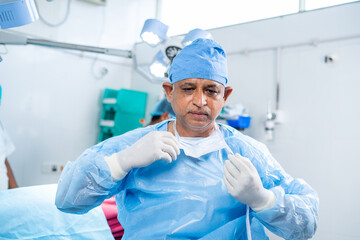 surgeon relaxing by removing surgical mask after successful surgery at operation theater - concept...