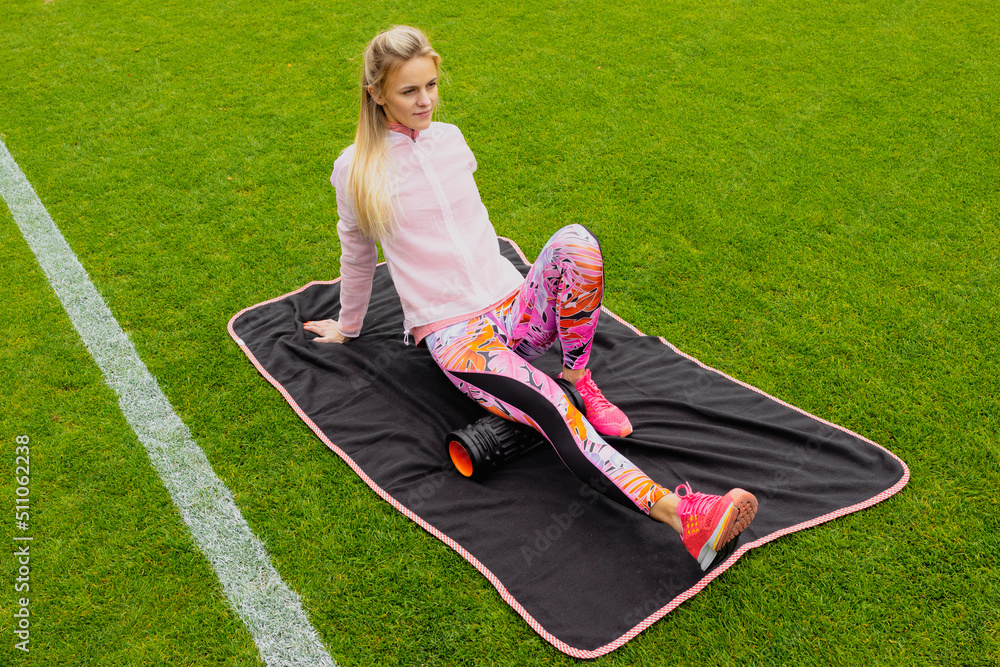 Wall mural the athlete warms up before training at an outdoor stadium. a female runner. a sporty lifestyle