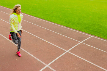 Outdoor training. A young woman runs around the stadium. Healthy lifestyle