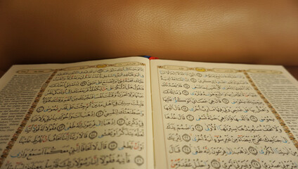 Fototapeta na wymiar An open page of Quran. Quran is an Islamic Holy Book for all muslims. Selective focus.