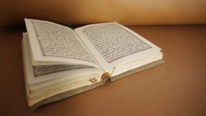 An open page of Quran. Quran is an Islamic Holy Book for all muslims. Selective focus.
