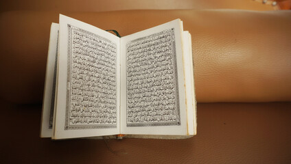 An open page of Quran. Quran is an Islamic Holy Book for all muslims. Selective focus.