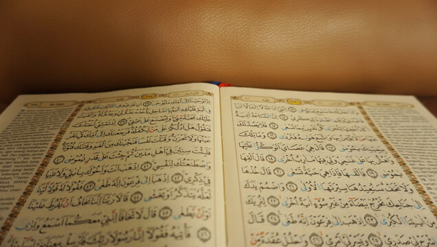 An open page of Quran. Quran is an Islamic Holy Book for all muslims. Selective focus.