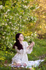 Cute girl with long hair and in a dress holding a bouquet of lilies of the valley