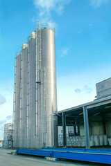 water injection systems in a beverage factory. pumping systems with towers containers cranes valves motors pipes and barrels