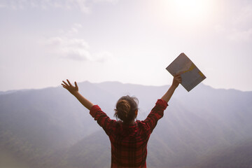 trekking concept, girl enjoying sunset on peak mountain, looking a map,traveler on background landscape.