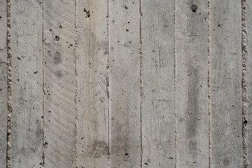 Grey concrete wall texture with vertical lines and cracks
