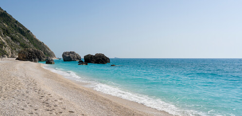 Beautiful summer Mediterranean pebble beach with small sea waves