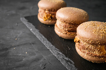 colored macaroons on a dark stone background