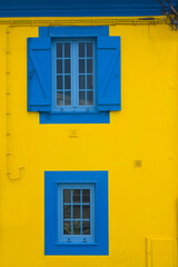 Fototapeta na wymiar Blue window on the yellow wall