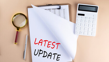 Clipboard with chart and text LATEST UPDATE with magnifier ,calculator on beige background