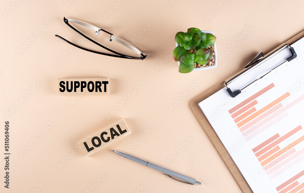 Poster support local text on wooden block with chart and glasses, business concept