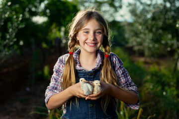 Optimistic girl with chicks on farm