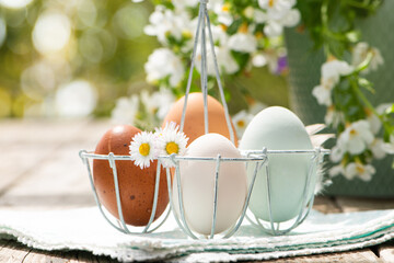 Colorful Easter eggs in a small metal egg basket