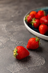 Fresh ripe strawberry on black texture background.Vegetarian organic berry.Healthy food.Copy space.Place for text