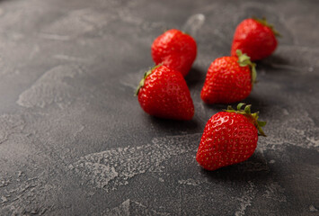 Fresh ripe strawberry on black texture background.Vegetarian organic berry.Healthy food.Copy space.Place for text
